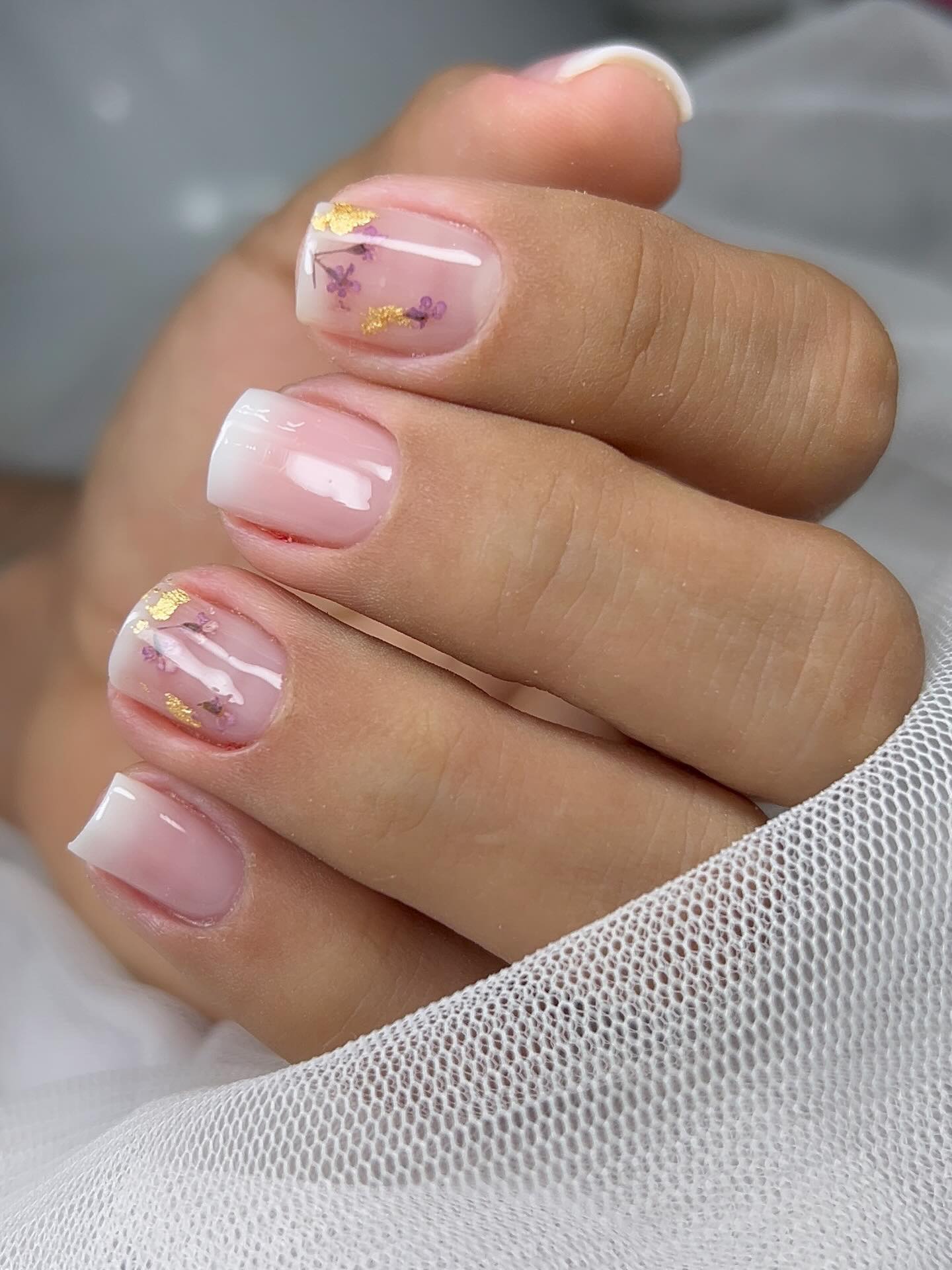 Nail design em unha curta com detalhe floral dourado, trabalho de Nara Costa Designer